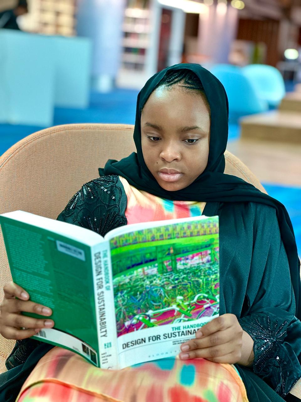 Zahra reading a book on sustainability